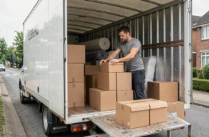 Homme chargeant des cartons dans un camion de déménagement 15m3 garé dans une rue résidentielle