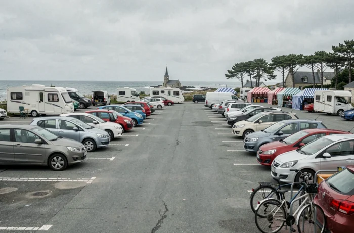 Vue large d'un parking public près du marché de Fort-Mahon-Plage avec voitures et vélos